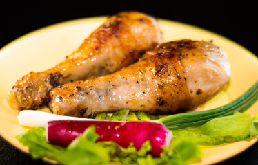 Appetizing fried chicken legs on plate with herbs