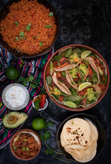 Vegetarian Mexican tacos and side dishes as filling served in traditional clay and cast iron pots