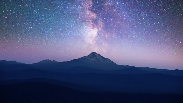 Time lapse of Milky Way over snowcapped mountain peak