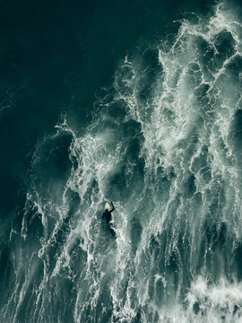 surfer paddling in rough seas