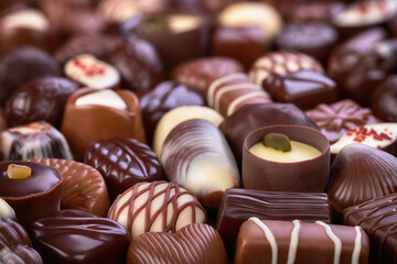 assorted chocolate candy with various fillings, sweet food background.