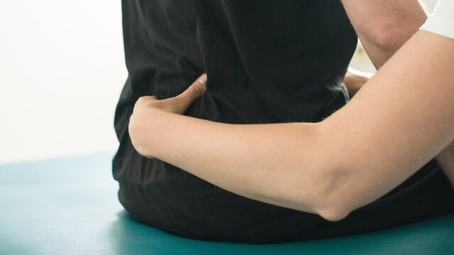 Physiotherapist exercising with disabled person on a therapy table.