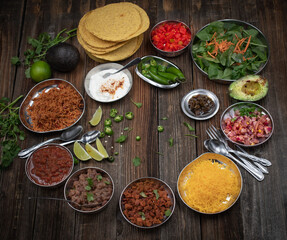 Vegetarian corn tostada with a variety of side toppings on wooden table