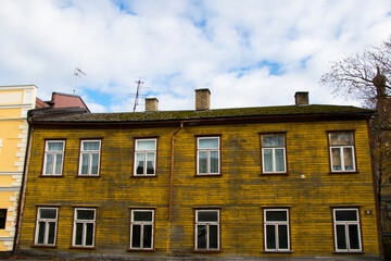 Old yellow village wooden house exterior in old town.
