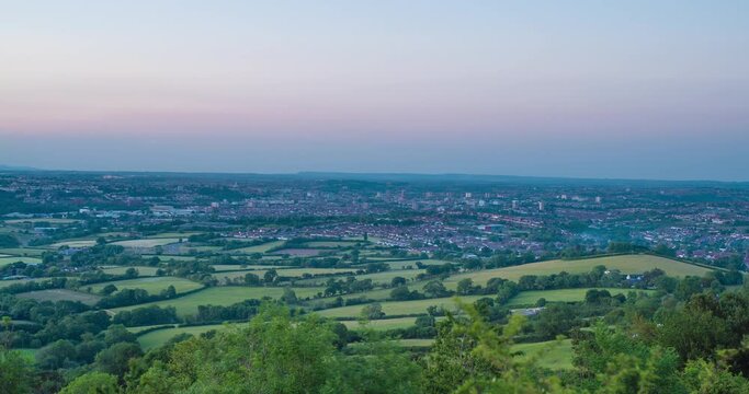 Sunset time lapse of distant city in green countryside of England