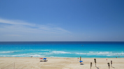 Fototapeta na wymiar Hermoso día de Playa soleado con arena blanca y mar turquesa en Cancún México 