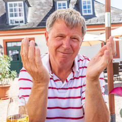 happy mature man sitting outside in a beergarden