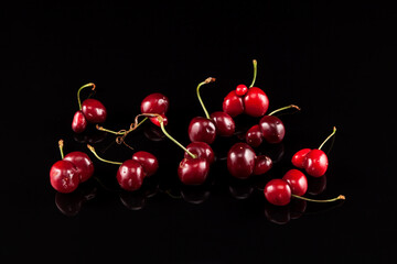 Heap of fresh fused cherry berries (cherries) on a dark background with reflection. Concept -...