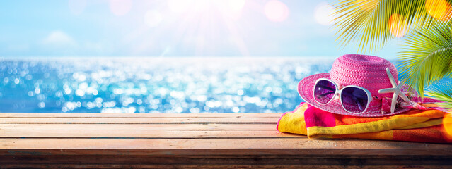 Fototapeta na wymiar Beach Accessories On Table With Shiny Sea On Background