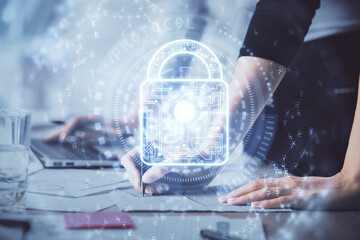 Double exposure of woman hands working on computer and lock hologram drawing. Security concept.