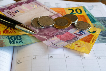 Financial control concept, with calendar, pen and Brazilian money. © Leonidas