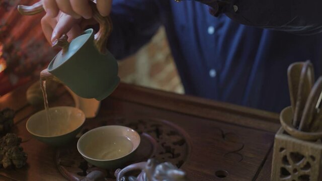 Man Pouring Green Tea from Teapot to Gaiwan at Traditional Chinese Tea Ceremony.