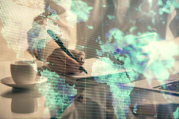 Double exposure of business theme sketch hologram and woman holding and using a mobile device.