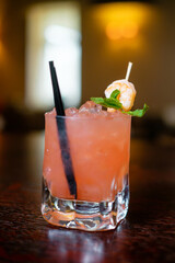 Making cocktails at home like an expert nightclub barman. Fresh and juicy colorful homemade cocktails garnished with orange, berry, mint.