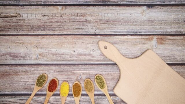 Cutting board and wooden eco friendly spoons with spices appear on bottom - Stop motion 
