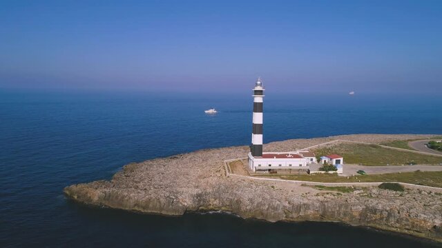Lighthouse on rocky cliff near sea