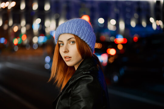beautiful red-haired girl in blue hat at night