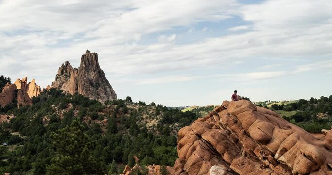 Time lapse panning shot of tourists on rock formation amidst trees at park against sky - Garden of the Gods, Colorado