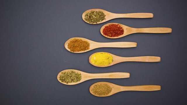 Eco friendly wooden spoons with various spices come from the right side - Stop motion 