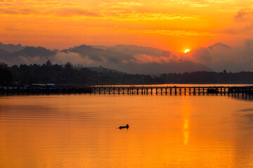 Fishermen are using boats to pass through the Mon Bridge. Mon Bridge is the long wooden bridge. Attanusorn Bridge. Sangkhla Buri, Kanchanaburi, Thailand.