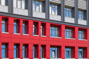 Red-gray modern ventilated facade with windows. Fragment of a new elite residential building or office center.