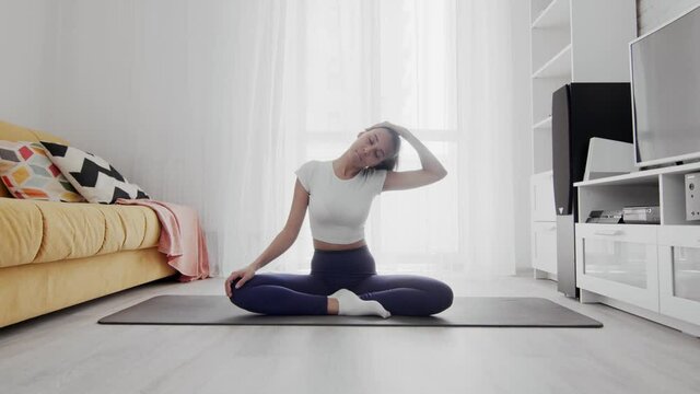 Young sporty african american woman stratching neck with closed eyes