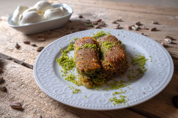 Traditional dessert, pistachio kadayif with ice cream on wooden background, top view, copy space. isolated.