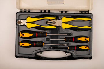 Various screwdrivers and pliers in a plastic case. Close up. Manual locksmith and installation tools for home work.