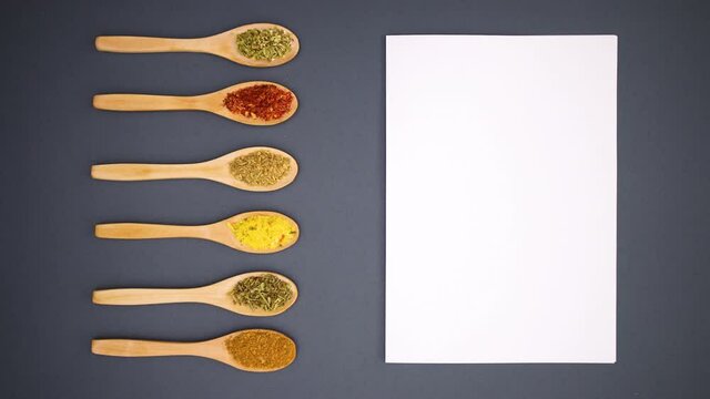 White paper and wooden spoons with spices appear - Stop motion 