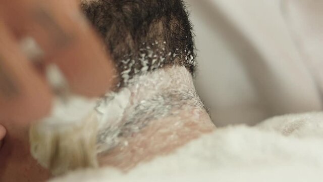 barber applying shaving cream to client beard slow motion