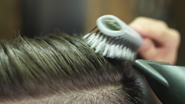 barber brushing client's hair with brush slow motion