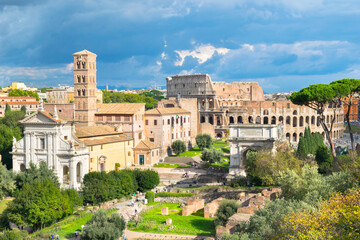 Fototapeta na wymiar Beautiful view of Roman Forum ruins (Foro Romano) with Colosseum in the background - Rome, Italy