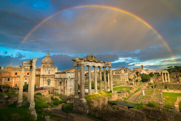 Beautiful sunset with rainbow in the Roman Forum ruins (Foro Romano) with Colosseum in the...