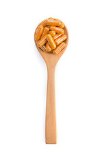 turmeric capsule in spoon on white background