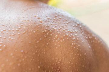Fototapeta premium Drops of water caused by sweat due to the hot weather on the back plate of the young man.