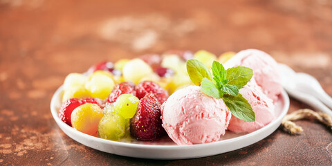 Balls of strawberry ice cream and fruit salad