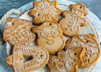 Homemade gingerbread cookies on tray on grunge gray  wooden background. Christmas and New Year celebration background.  Close up of home baked cookies with icing.