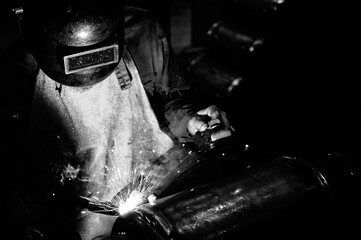 Fototapeta na wymiar welder working welding process on metals with welding mask and individual protection equipment