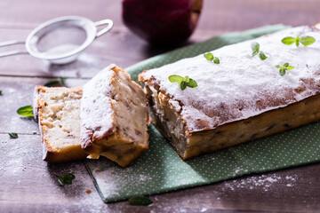 Homemade  apple pie on the green napkin decorated with fresh red  apples,, mint leaves. Vegetarian tart on the wooden background. Delicious autumn dessert.