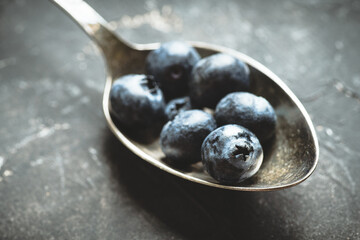 Freshly harvested blueberries on the spoon. Selective focus. Shallow depth of field.