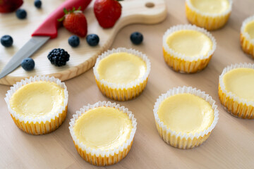 Mini cheesecake with blueberry, blackberry and strawberry ready to be served on wooden table
