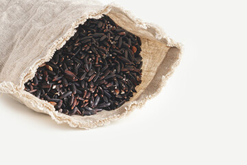 Black wild rice in pouch on white blank space. Close up.