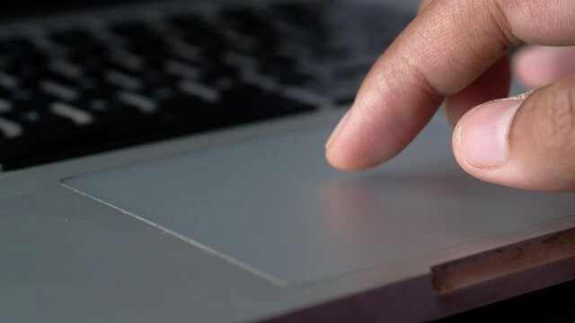 Man finger scrolling on laptop mouse pad