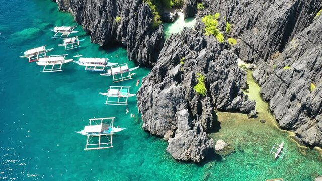 Philippines Coastline Drone Aerial View. Secret Beach and Double Outrigger Boats in El Nido, Palawan Island Archipelago
