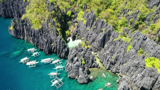 Secret Beach, El Nido, Palawan Island, Philippines. Aerial View of Double Outrigger Boats and Majestic Coast