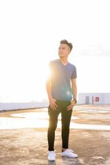 Full body shot of young handsome multi ethnic man thinking at rooftop of the building