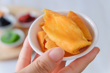 Dried fruit, Yellow mango slice in woman's hand. Close-up