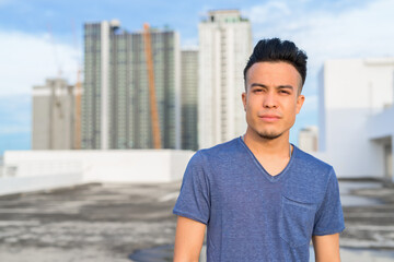 Young handsome multi ethnic man against view of the city