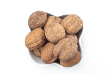 Walnuts in a white bowl. Clean surface. Top view | above, heart shaped nut. Isolated. Copy space for text editing, white background. Close up