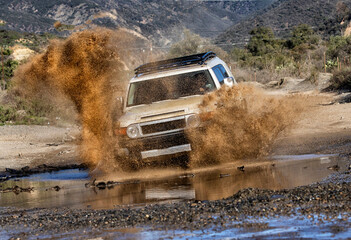 A 4x4 vehicle  driving through puddle with water splashing Trabucco Canyon Ca